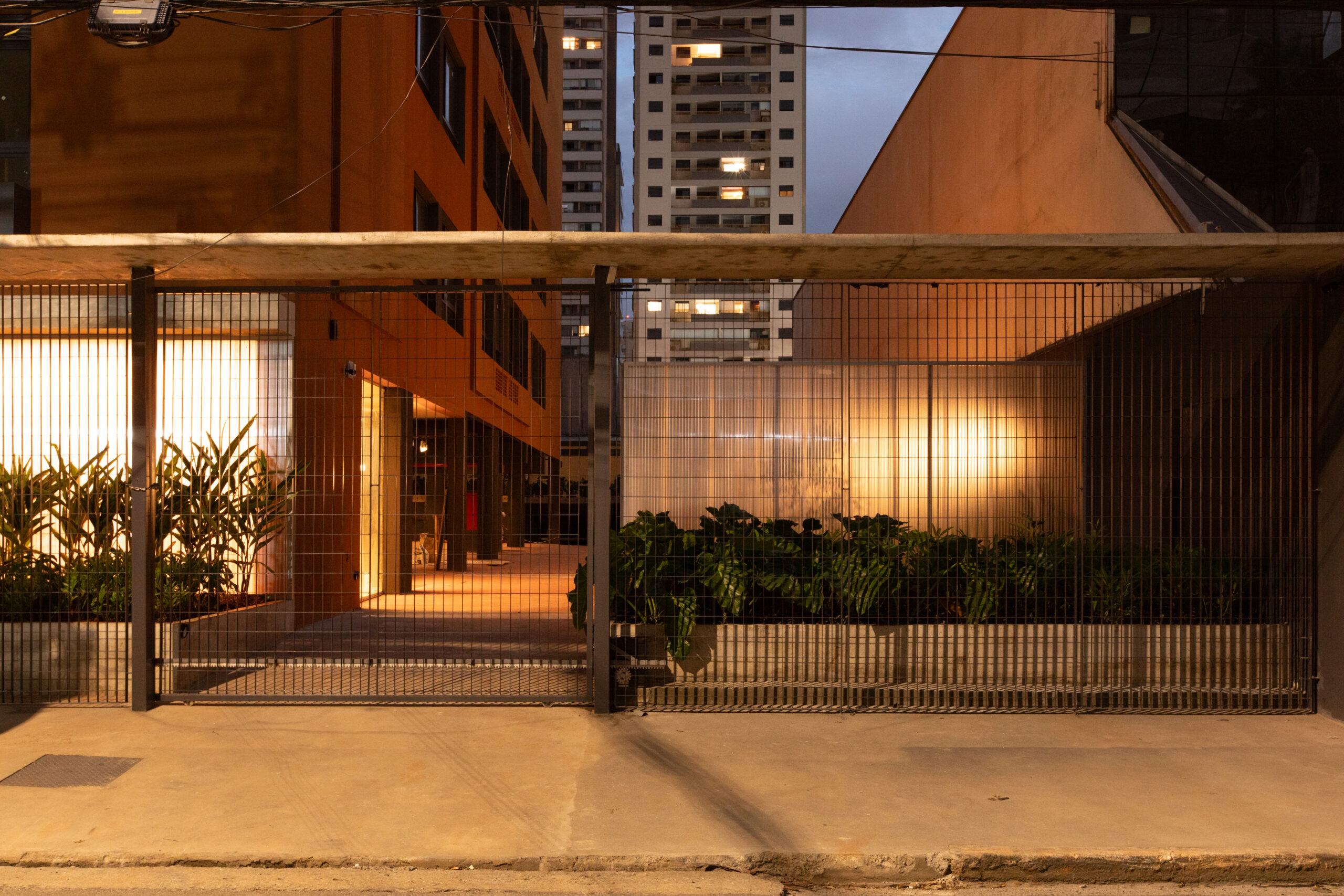Entrada iluminada à noite — plantas e vidro canelado